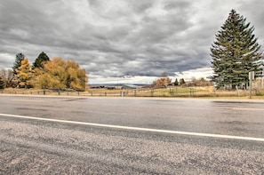 A road with a fence and trees in the background.