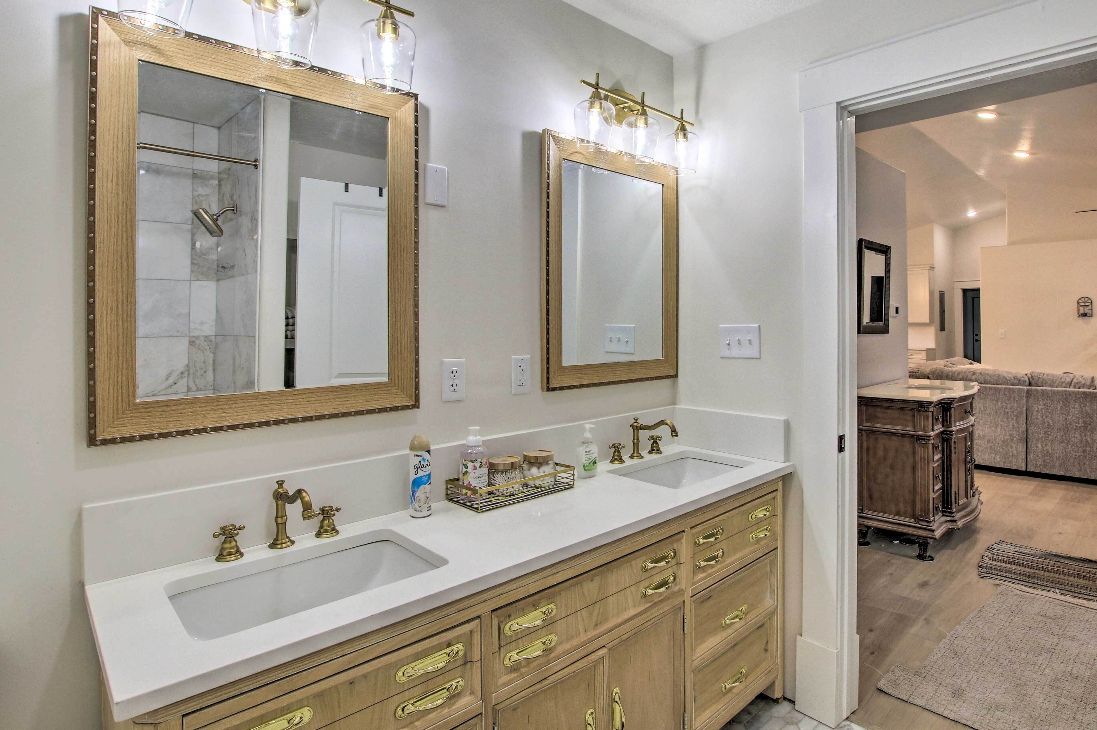 A bathroom with two sinks, wooden vanity, and large mirrors.