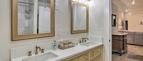 A bathroom with two sinks, wooden vanity, and large mirrors.