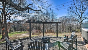 A gazebo with Adirondack chairs, a fire pit, and a hot tub in a park setting. - 'the Retreat on Reno' Home w/ Hot Tub + Deck! (Reeds Spring)