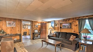 Un salon chaleureux avec des murs en bois, un canapé, une table basse et une lampe.