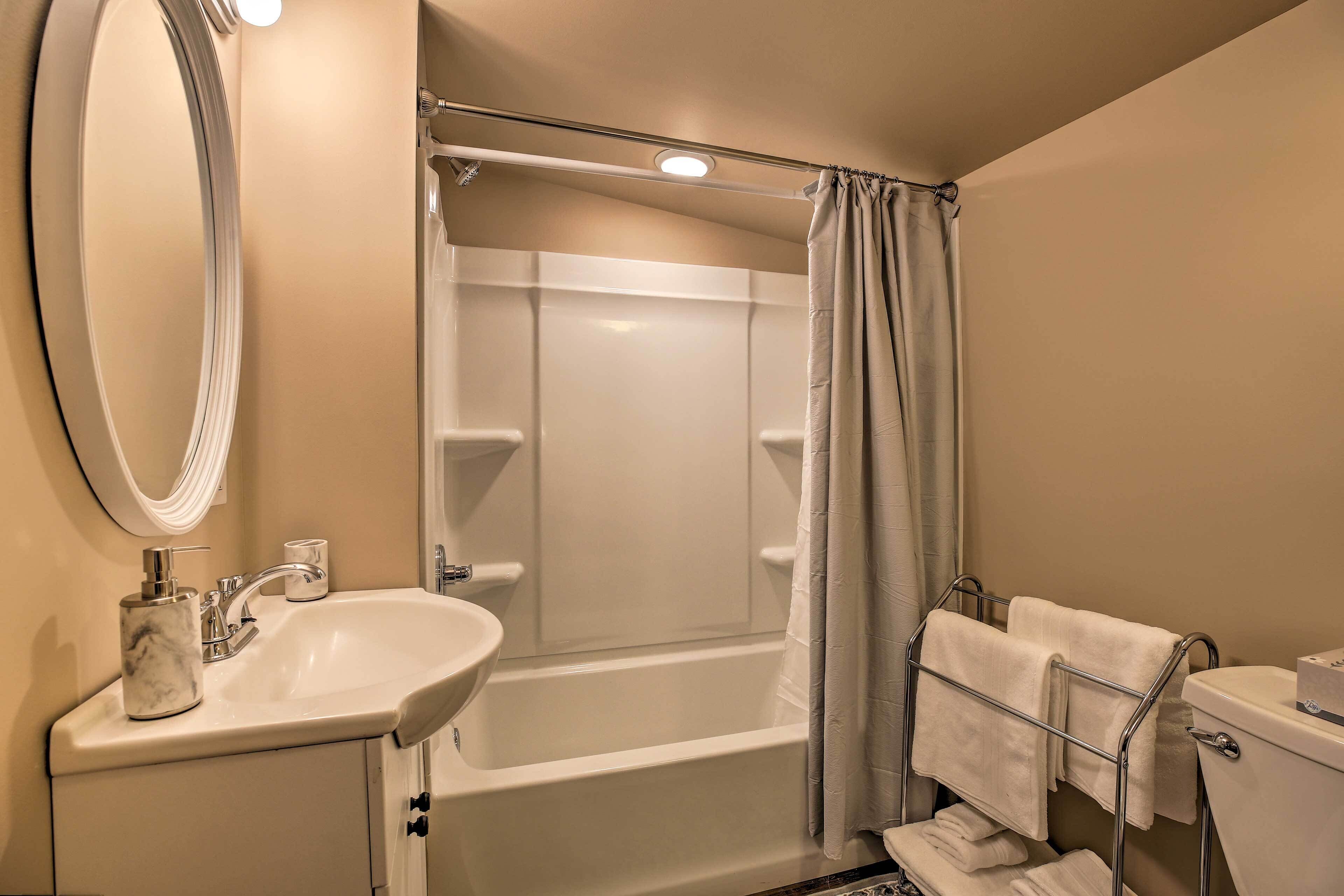 Un baño con bañera, lavabo, inodoro y un perchero para toallas.