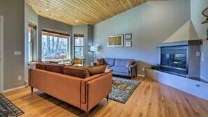 A spacious living room with wooden flooring, a high ceiling, and large windows. - Cozy Carbondale Escape w/ Deck & Grill! (Carbondale)