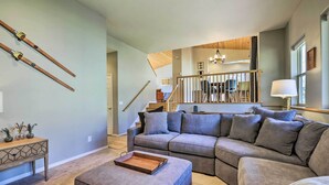 A modern living room with a sectional sofa, a wooden coffee table, and a console table with decorative items. - Cozy Carbondale Escape w/ Deck & Grill! (Carbondale)