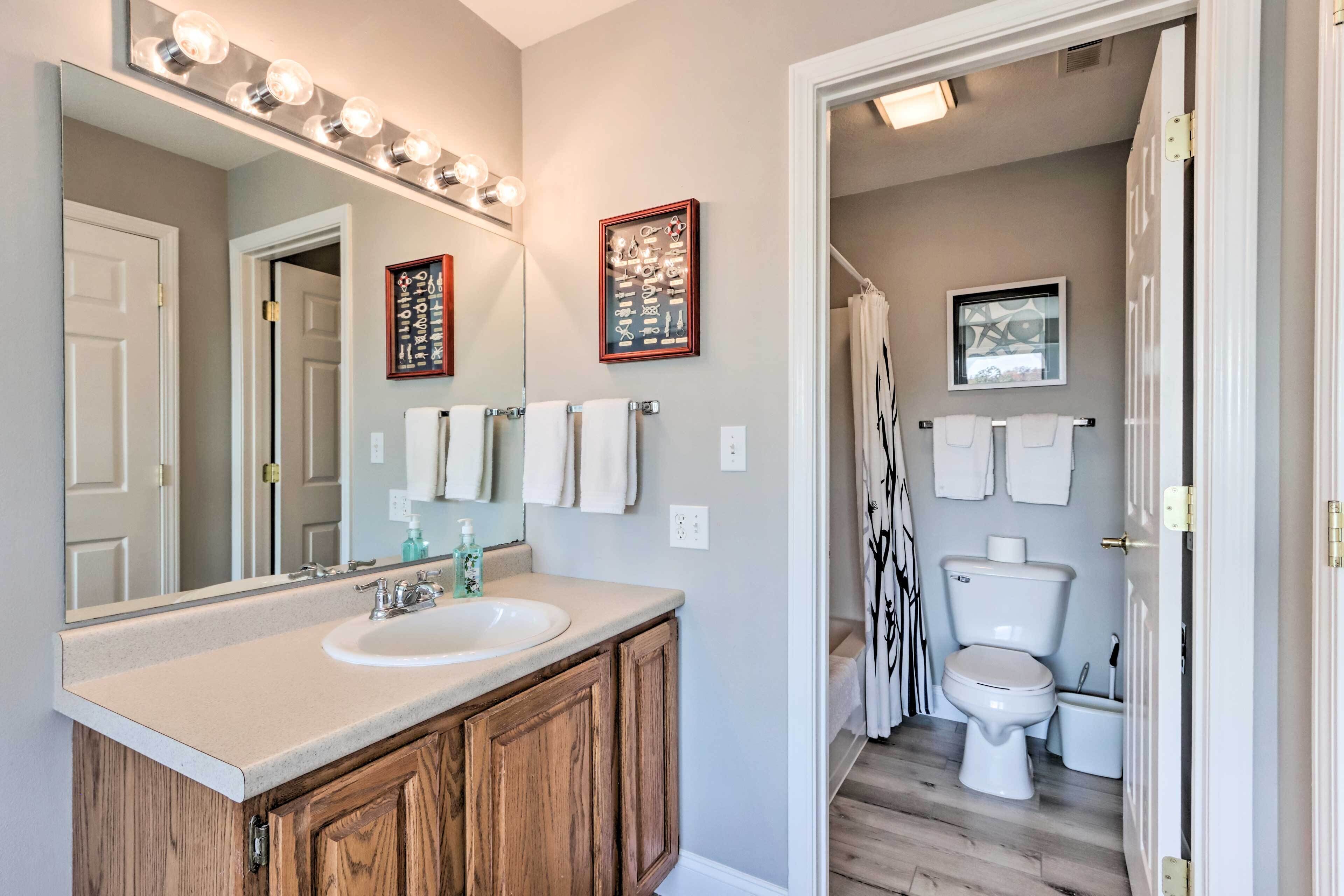 A bathroom with a vanity, sink, mirror, and towel rack.