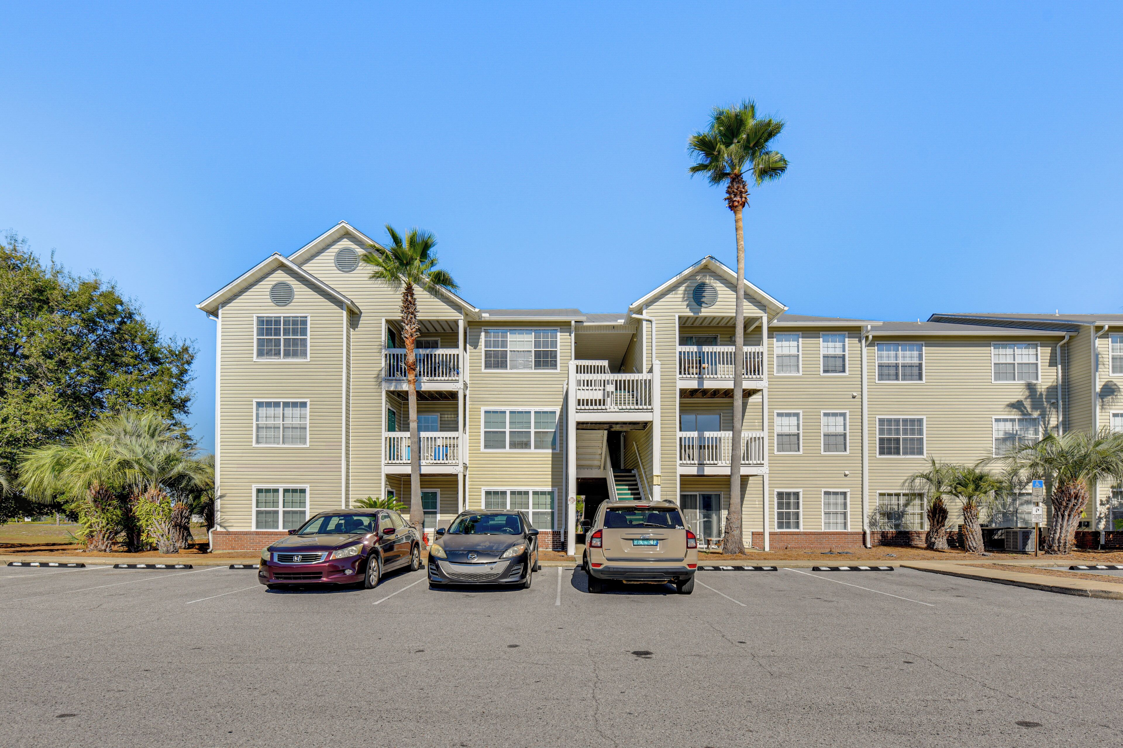 A multi-story hotel with a parking lot in front.