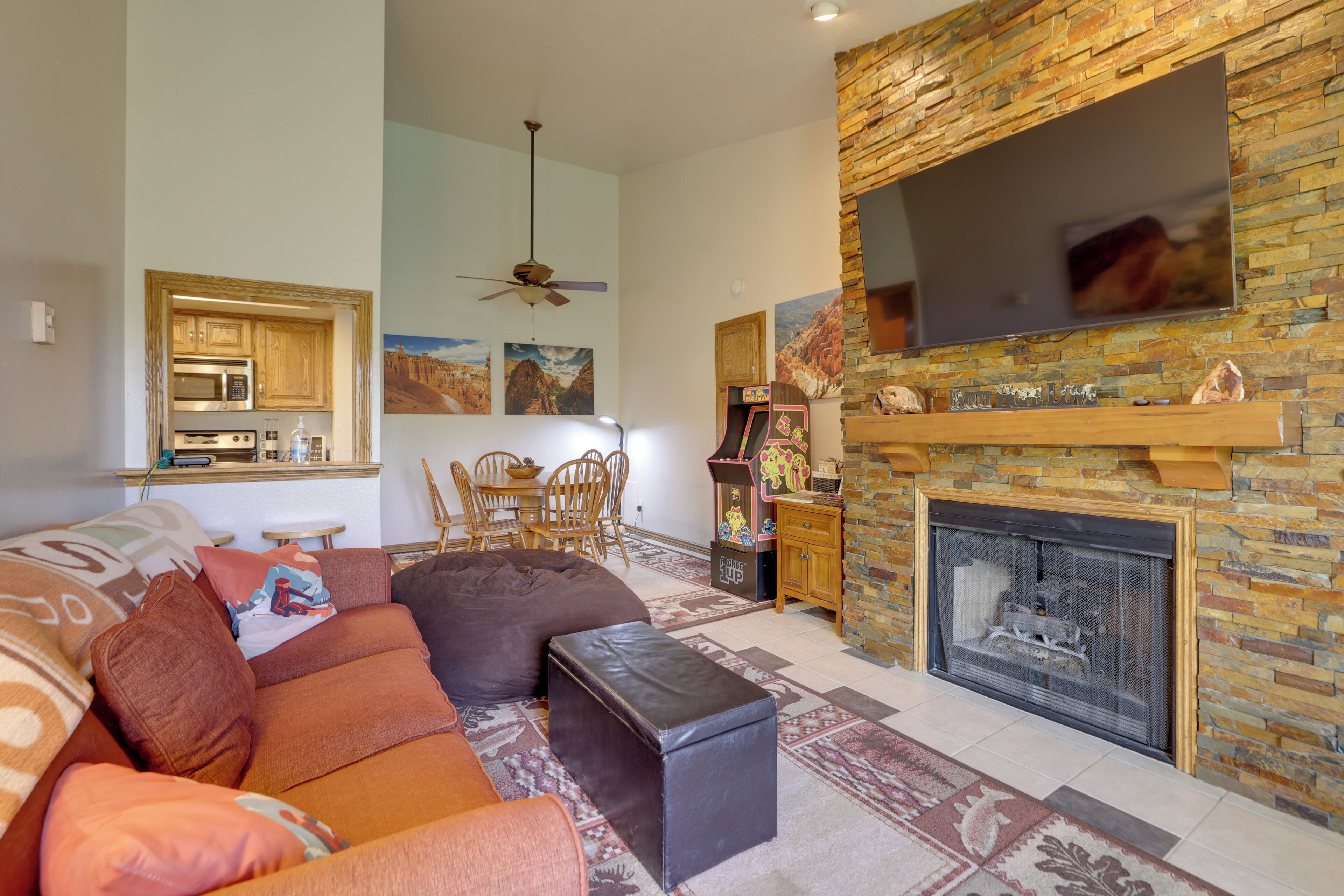 A living room with a fireplace, a sofa, a coffee table, and a television mounted on a stone wall.