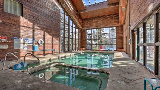 Ein Hallenbad mit Holzwänden und großen Fenstern.