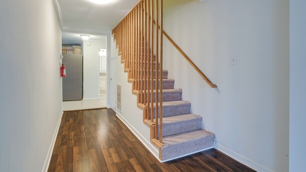 Eine Treppe mit Holzwangen und Teppichstufen, die zu einer oberen Etage führt.