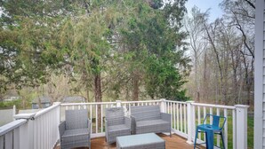 Eine überdachte Terrasse mit Korbmöbeln und einem blauen Stuhl.
