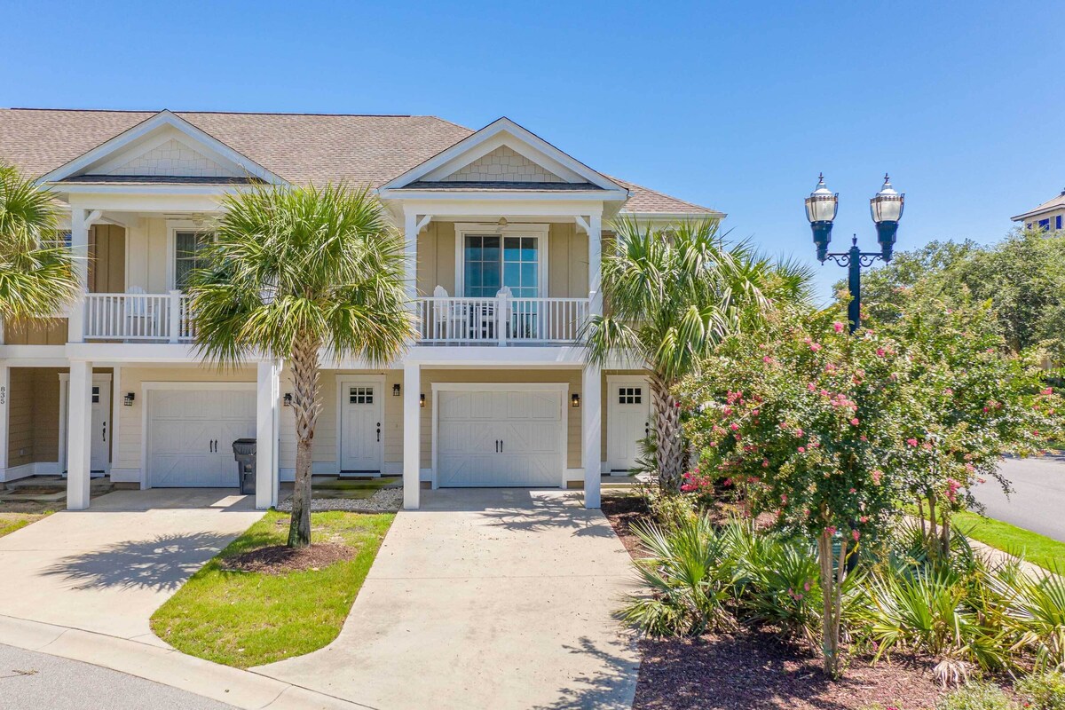 A two-story house with a front porch, a garage, and a well-maintained lawn.