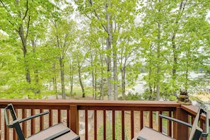 A wooden deck with two chairs and a view of a forest and water. - North Carolina Retreat - Deck, Grills & Lake Views (High Point)
