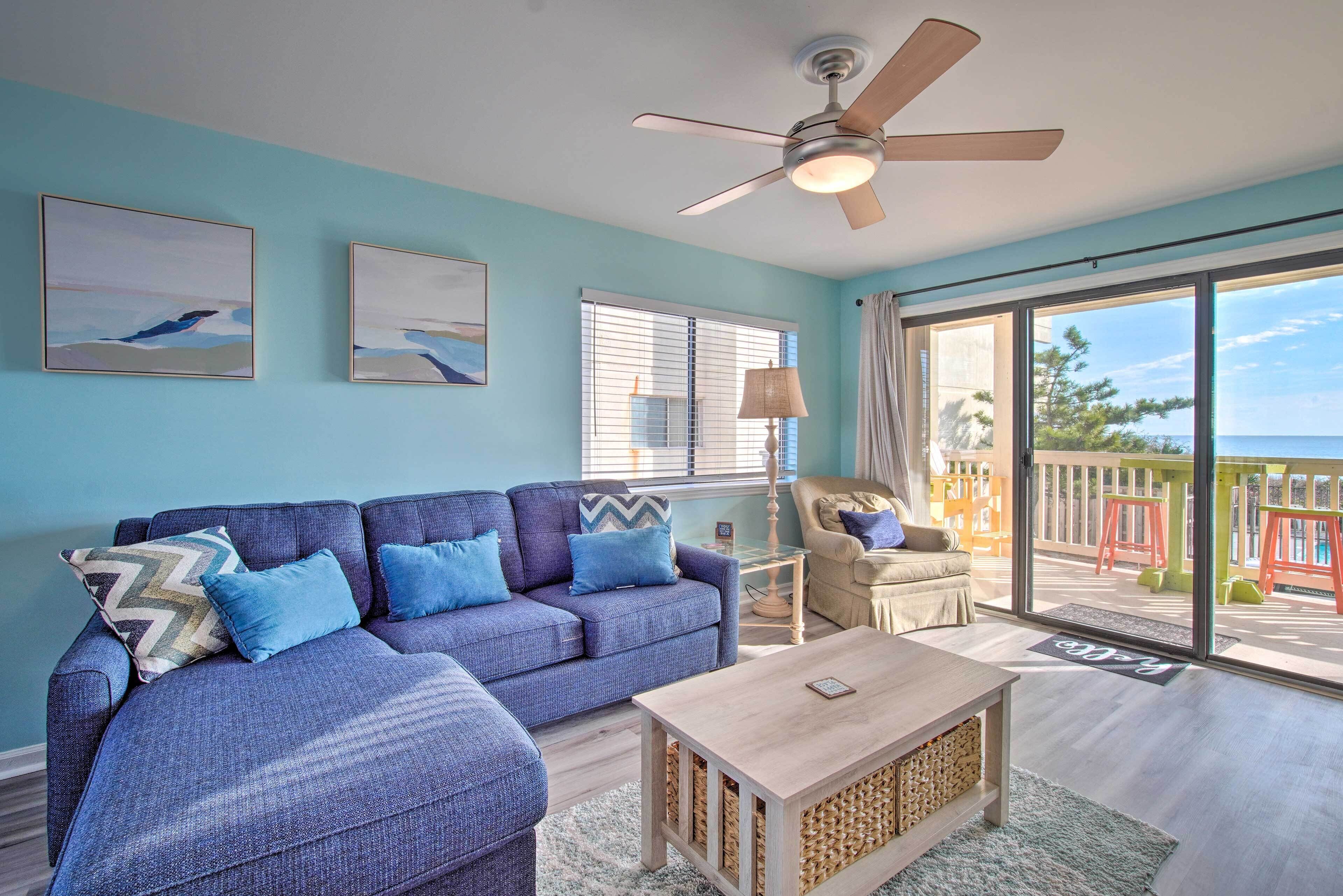 A living room with a blue sofa, a wooden coffee table, and a ceiling fan.