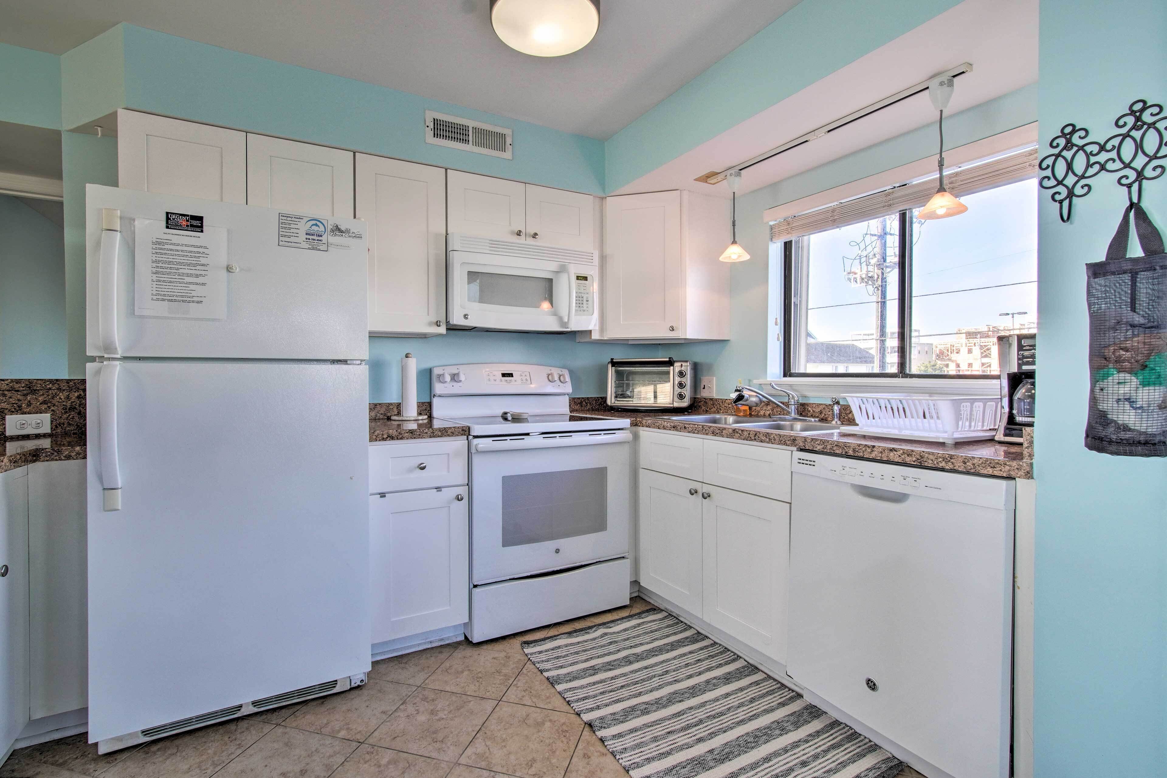 A compact kitchen with white cabinets, a microwave, a stove, and a dishwasher.