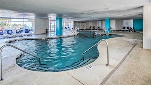 An indoor swimming pool with clear water, a 3ft depth marker, and lounge chairs around the pool area. - Oceanfront Resort Condo in North Myrtle Beach (North Myrtle Beach)