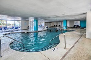 An indoor swimming pool with clear water, a 3ft depth marker, and blue chairs around the pool area. - Oceanfront Resort Condo in North Myrtle Beach (North Myrtle Beach)