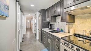A modern kitchen with dark cabinets, a stainless steel range, and a marble backsplash. - Oceanfront Resort Condo in North Myrtle Beach (North Myrtle Beach)