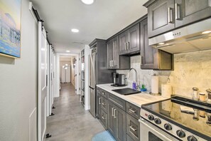 A modern kitchen with dark cabinets, a stainless steel range, and a marble backsplash. - Oceanfront Resort Condo in North Myrtle Beach (North Myrtle Beach)