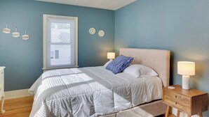 Una camera da letto con un letto, comodini, una finestra e decorazioni alle pareti.