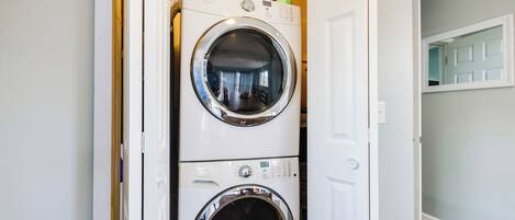 A laundry room with two stacked front-loading washing machines.