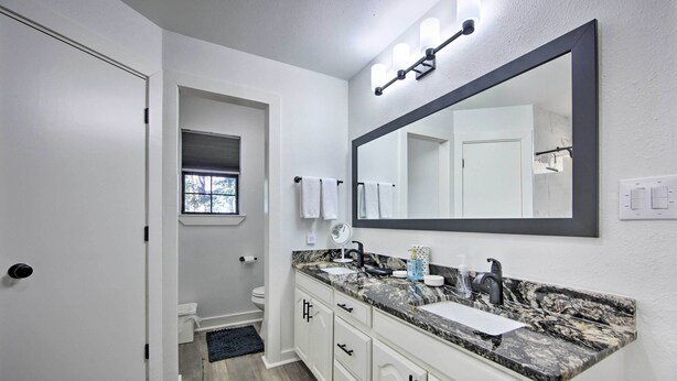 A modern bathroom with a large mirror, dual sinks, and a vanity with drawers. - Luxe Lakehouse w/ Sunset Views on Lake Palestine! (Flint)