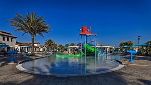 A water park with a central pool, a green slide, and blue play structures. - Kissimmee Retreat With Private Pool & Spa (Kissimmee)