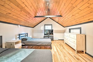 A bedroom with two beds, a dresser, a TV, and a wooden ceiling. - Game Room, Fire Pit & Deck: Spacious Poconos Home! (Lake Harmony)