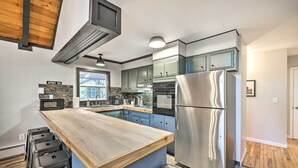 A modern kitchen with a central island, stainless steel appliances, and a view of the outside. - Game Room, Fire Pit & Deck: Spacious Poconos Home! (Lake Harmony)