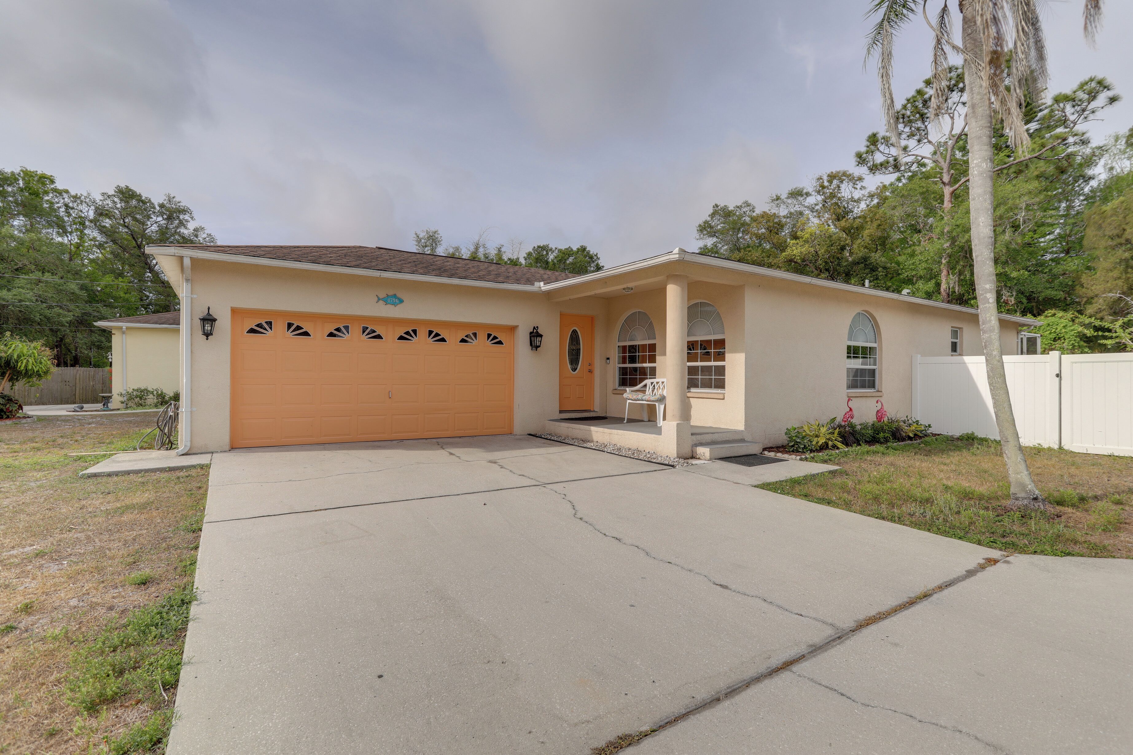 A single-story house with a garage, a front porch, and a small garden.