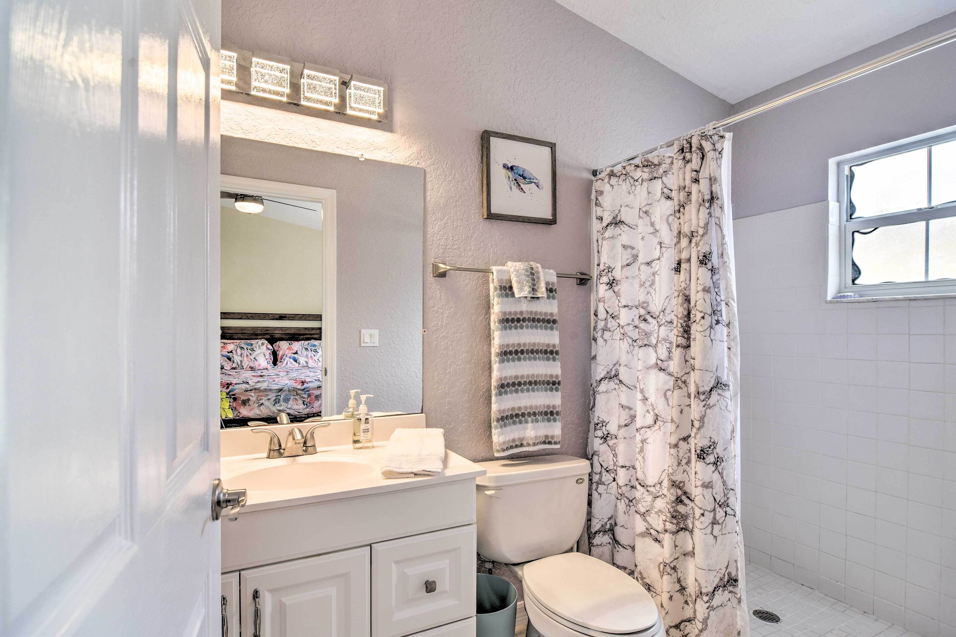 A bathroom with a toilet, sink, and mirror.
