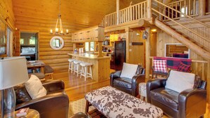A log cabin interior with a kitchen, dining area, and living room.