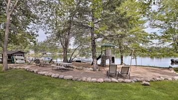 Un parc au bord du lac, équipé de tables de pique-nique, d’une balançoire et d’un kiosque.