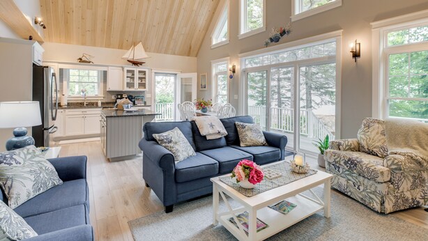 A spacious living area with a high ceiling, large windows, and a cozy seating arrangement. - Oceanfront Prospect Harbor House w/ Deck, View (Prospect Harbor)