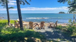 A beachside seating area with chairs and tables, overlooking the ocean. - Oceanfront Prospect Harbor House w/ Deck, View (Prospect Harbor)