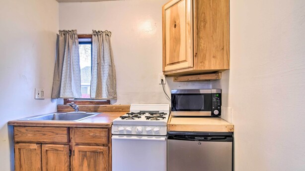 A compact kitchen with wooden cabinets, a gas stove, a microwave, and a dishwasher. - Loveland Vacation Rental - 1 Mile to Lake! (Loveland)