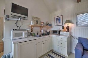 A compact kitchen with white cabinets, a microwave, a toaster, and a small shelf with decorative items. - Pauls Cottage in Tenants Harbor, 1 Min to Shore (Tenants Harbor)
