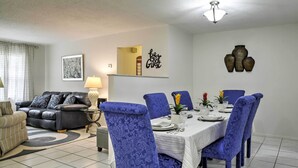 A dining area with a table set for four, surrounded by blue upholstered chairs. - Spacious Central Florida Home: Family Friendly! (Longwood)