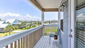 A covered porch with a view of neighboring houses and a clear sky. - Mexico Beach Getaway w/ Balcony & Ocean Views! (Port St. Joe)