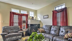 A living room with two leather sofas, a glass coffee table, and a fireplace. - Maryland Vacation Rental Near Baltimore (Perry Hall)