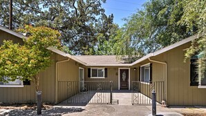 A two-story building with a central entrance, a small porch, and a gated driveway.