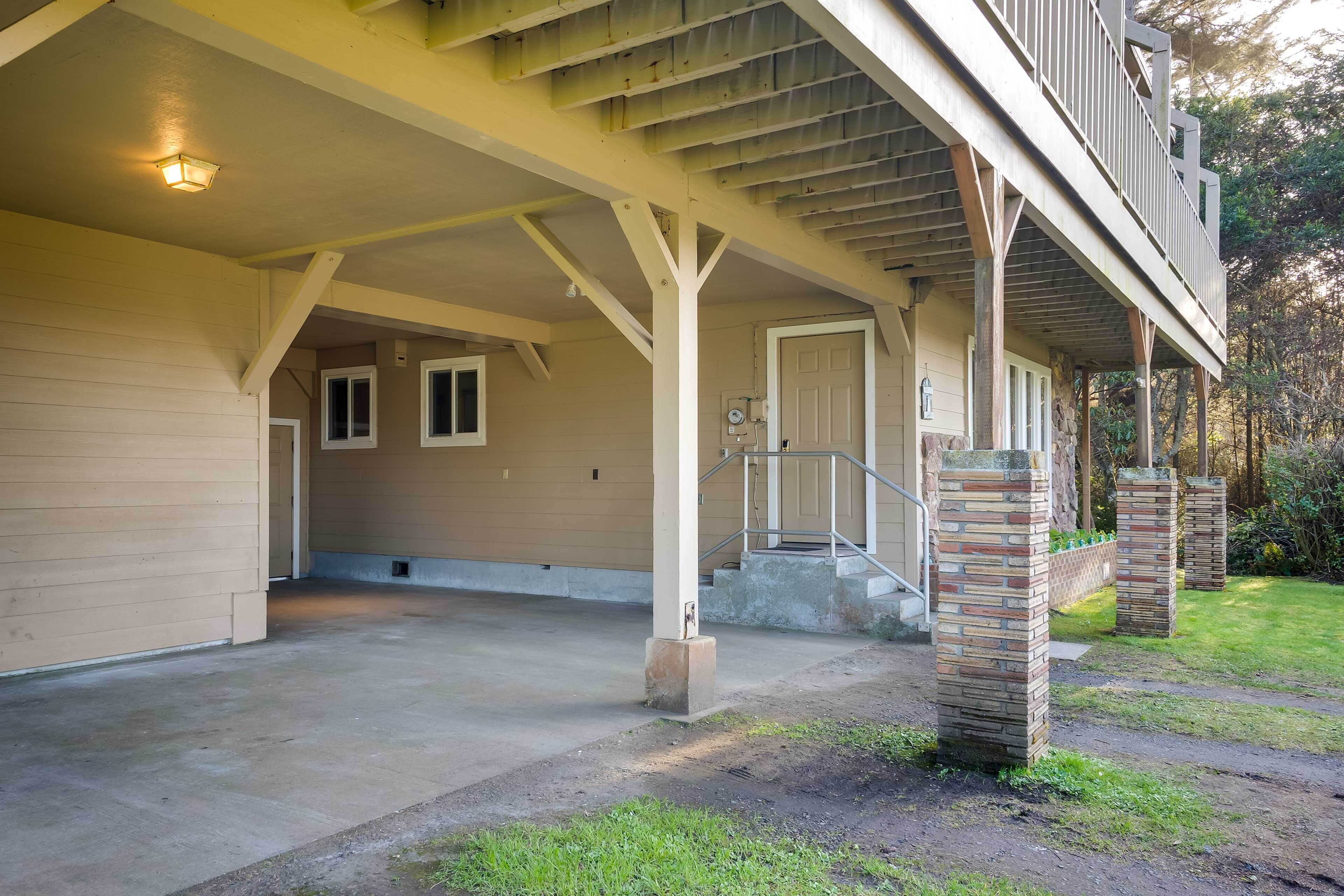 A two-story building with a covered porch, a door, and a small outdoor area with steps leading up to the porch.