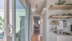 Una cocina moderna con pileta integrada, estantes de madera y vista al exterior.