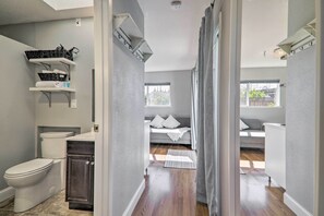 A modern bathroom with a toilet, sink, and storage shelves.