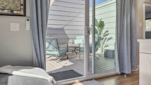 Una habitación con puerta corrediza de vidrio que da a un patio exterior.