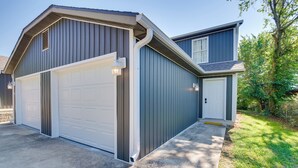 Une maison à deux étages avec un garage et une véranda couverte.