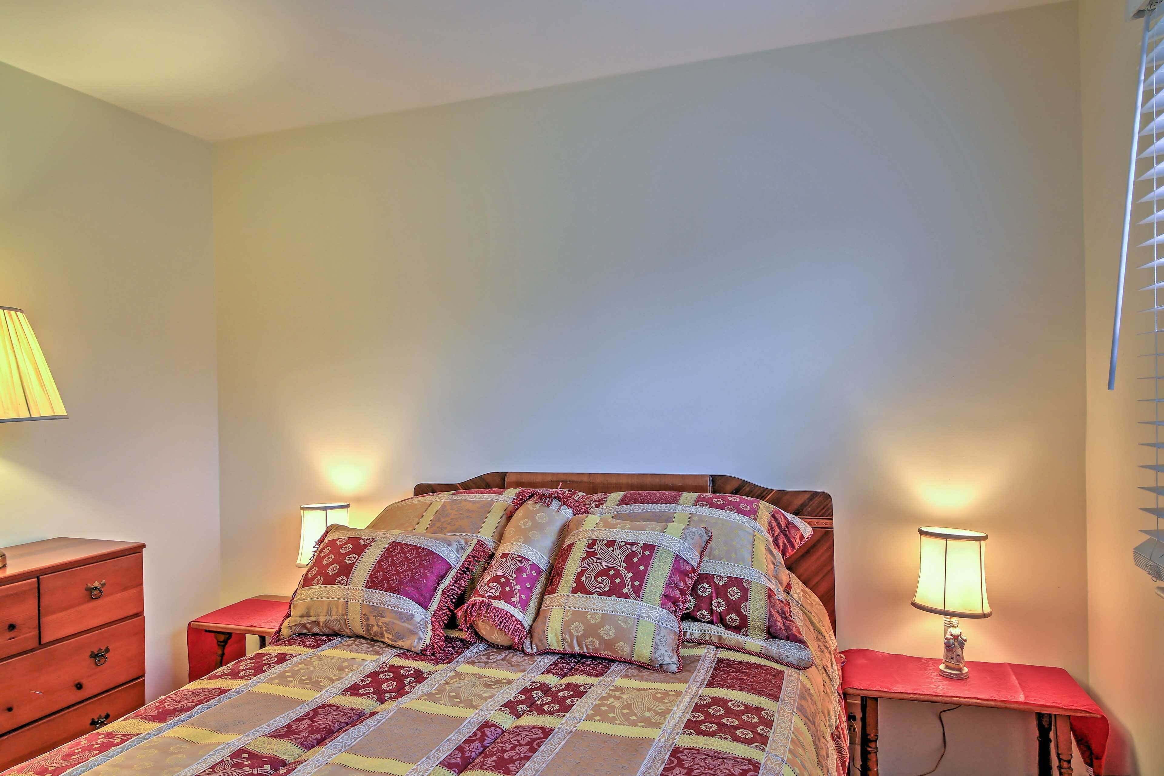 Un dormitorio con una cama, dos mesitas de noche y una mesilla.