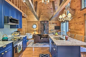A cabin interior with a kitchen, dining area, and a fireplace.