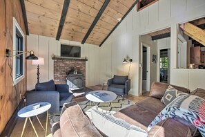 A cozy living room with a fireplace, wooden ceiling beams, and comfortable seating. - Sleek Cabin w/ Deck, 8 Miles to Mount Snow & Hikes (Wilmington)