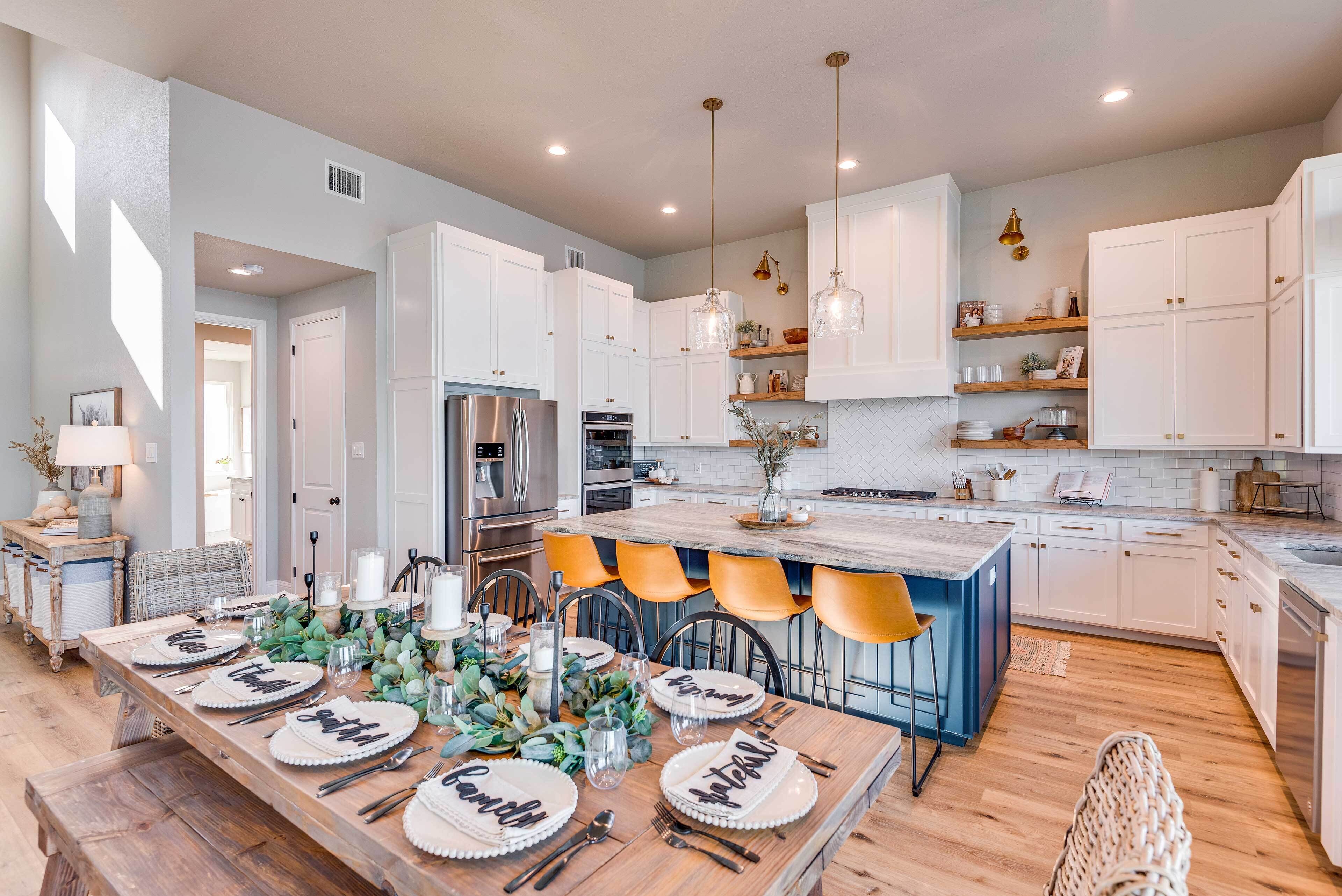 A modern kitchen with white cabinets, a central island, and bar stools.