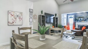 A dining area with a wooden table, chairs, and a central potted plant. - 3 Mi to Boardwalk: Bethany Beach House w/ Patio! (Ocean View)